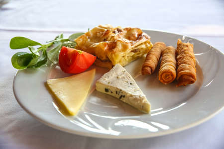 Cheese and pastry with tomato and herbsの写真素材