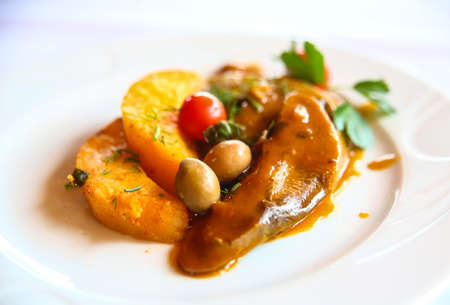 Beef tongue with potato and olives in sauce