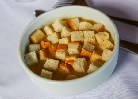 Soup with croutons and fresh green herbsの写真素材