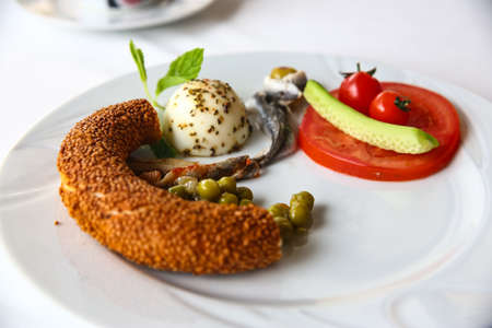 Breakfast with egg, bread, peas, tomato and anchovyの写真素材