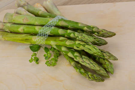Raw asparagus heap on the wood backgroundの写真素材
