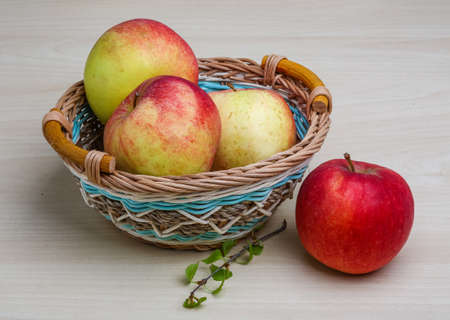 Few apples in the basket on wood backgrondの写真素材