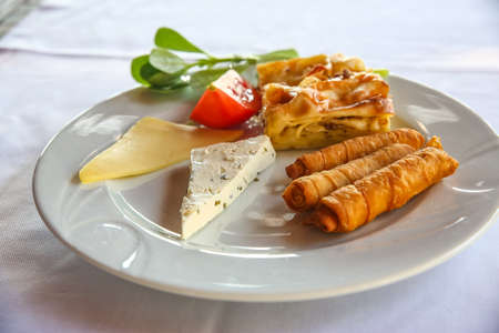 Cheese and pastry with tomato and herbsの写真素材