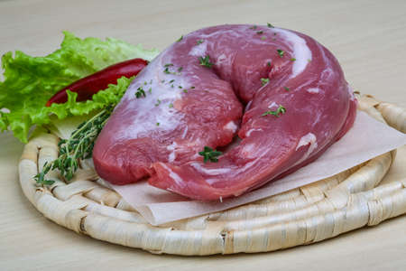 Raw pork tenderloin with thyme and pepper - ready for cookingの写真素材