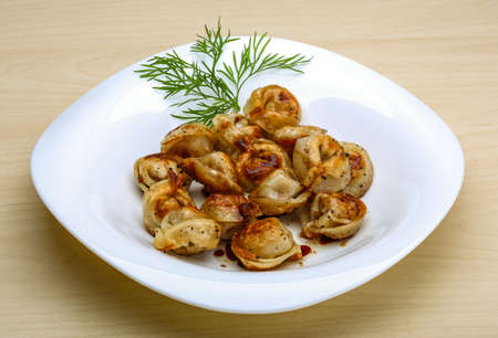 Fried russian dumplings with dill on woodの写真素材