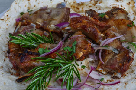 Grilled lamb ribs with onion, rosemary and breadの写真素材