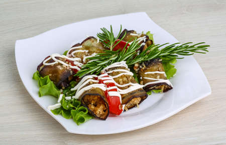 Aubergine roll with cheese and walnut served tomato, salad, rosemaryの写真素材