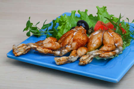 Fried frog legs with olive, herbs and spicesの写真素材