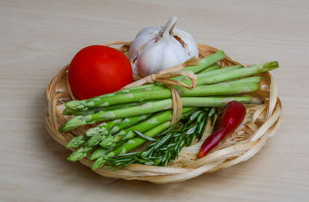 Raw asparagus heap with rosemary leaves on the wood backgroundの写真素材