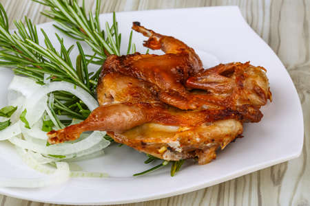 Grilled quail with rosemary on the wood backgroundの写真素材