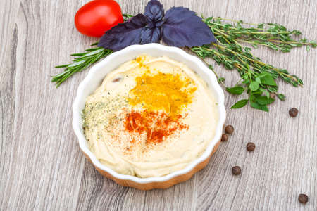 Hummus with pepper, rosemary, basil and thymeの写真素材