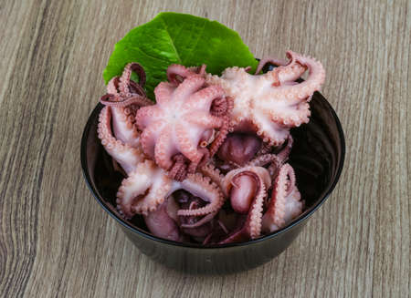 Marinated baby octopus in the bowl on wood backgroundの写真素材
