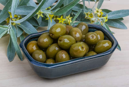 Green olives in the bowl with leavesの写真素材