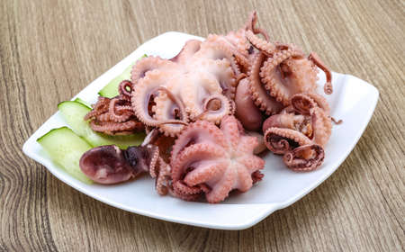 Marinated baby octopus in the bowl on wood background