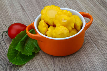 Pickled yellow patissons with salad leaves and fresh tomatoの写真素材