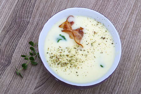 Cheese soup with bacon and herbs on the wood backgroundの写真素材