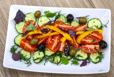 Salad with tomato, cucumber and olives served sesame seedsの写真素材