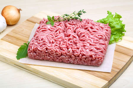 Minced meat served thyme, onion and garlic - ready for cookingの写真素材