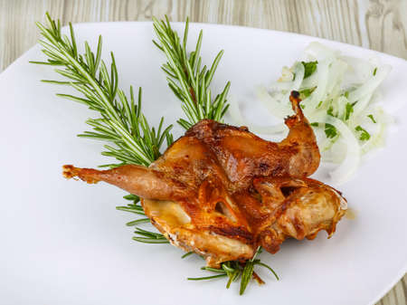 Grilled quail with rosemary on the wood backgroundの写真素材
