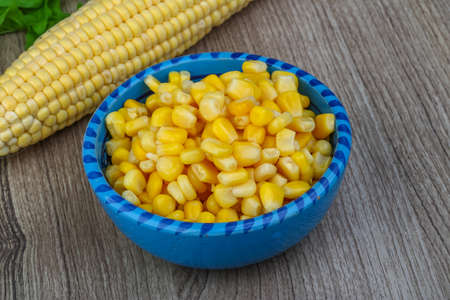 Canned sweet corn in the bowl on wood backgroundの写真素材