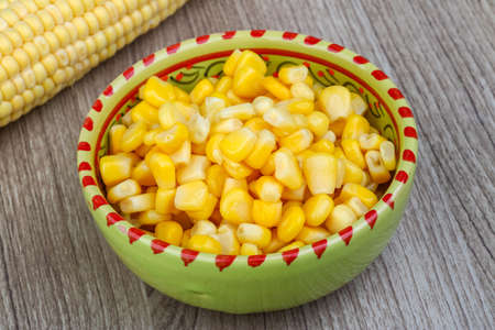 Canned sweet corn in the bowl on wood background