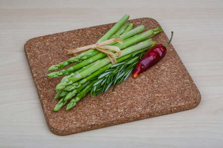 Raw asparagus heap with rosemary leaves on the wood backgroundの写真素材