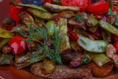 Stir fried pork with vegetables - green bean, tomato, pepper and dillの写真素材