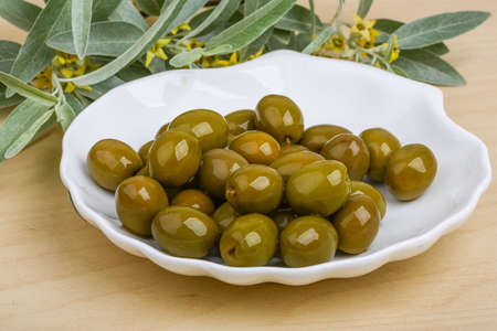 Green olives in the bowl with leavesの写真素材