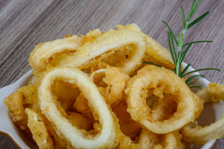 Fried squid rings with lemon, herbs and spicesの写真素材