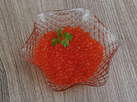 Red caviar in the bowl with green parsley leafの写真素材
