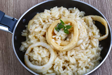 Italian famous cuisine - Squid risotto served basil leavesの写真素材
