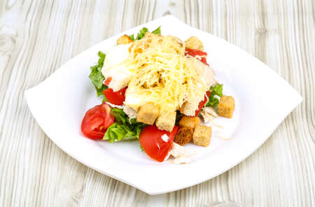 Caesar salad with chicken on the wood backgroundの写真素材