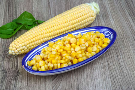 Canned sweet corn in the bowl on wood background