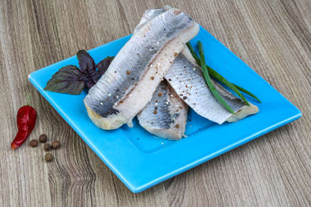 Herring fillet with green onion, basil leaves and pepperの写真素材