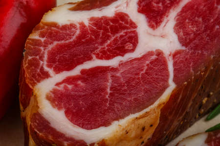 Chuck steak with rosemary, pepper and garlik on wood background