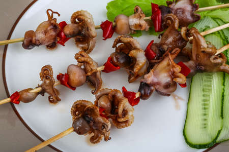 Grilled octopus skewers with red pepper and onionの写真素材