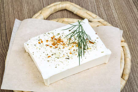 Feta cheese with dill leaves and spices on wood backgroundの写真素材