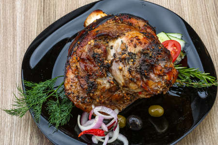 Roasted pork knee with dill and rosemary on the wood backgroundの写真素材