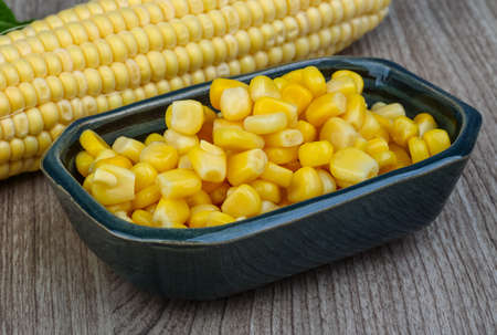 Canned sweet corn in the bowl on wood background