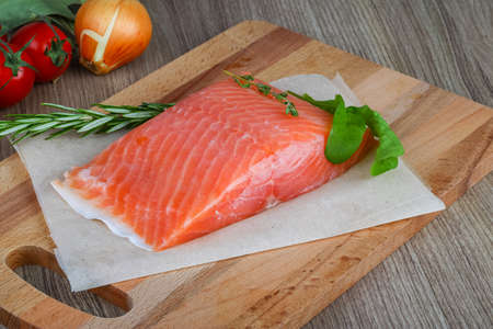 Salted salmon with rosemary and thyme on the wood backgroundの写真素材