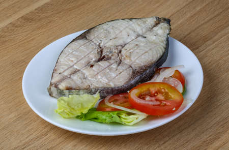 Grilled tuna steak with salad leaves ant sliced tomatoの写真素材