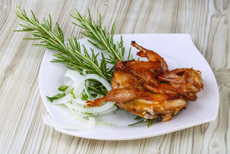 Grilled quail with rosemary on the wood backgroundの写真素材