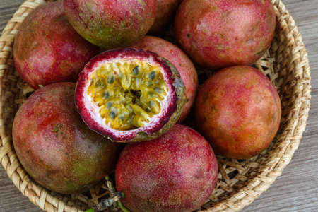 Fresh tropical fruit - Passionfruit - in the basket o wood backgroundの写真素材