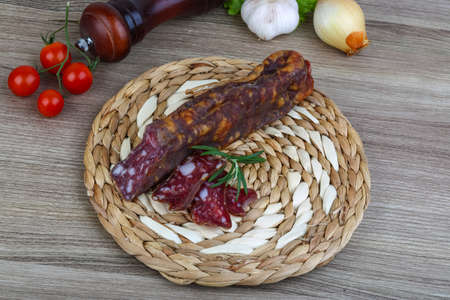 Salami sausage with rosemary on the wood backgroundの写真素材