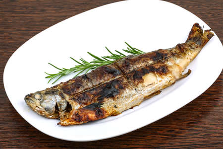 Grilled trout served green rosemary branch on the wood backgroundの写真素材