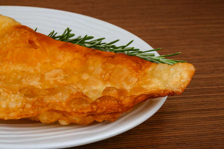 Traditional Meat Cheburek served rosemary on the wood backgroundの写真素材