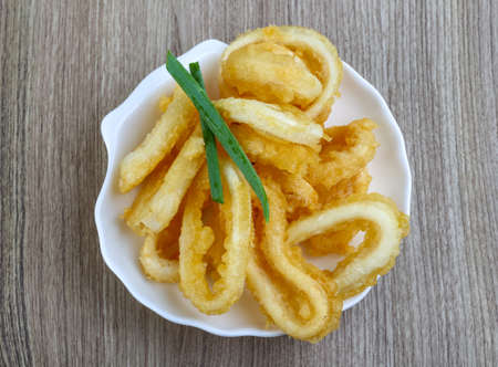Fried squid rings with lemon, herbs and spicesの写真素材