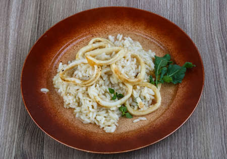 Italian famous cuisine - Squid risotto served basil leavesの写真素材