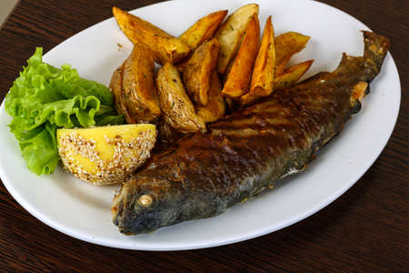 Grilled trout with potato, salad leaves and lemon