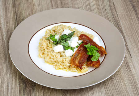 Risotto with mozzarella, basil leaves and baconの写真素材